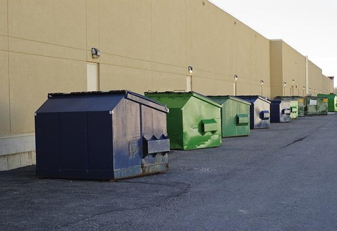 a compact construction dumpster being emptied by a waste disposal truck in Columbus